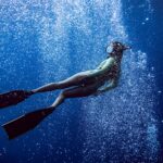 woman in black one piece swimsuit under water