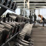 woman standing surrounded by exercise equipment