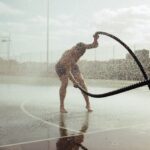 a man is playing in the water with a hose